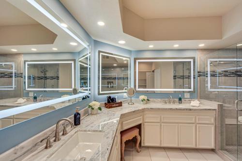 a bathroom with two sinks and two mirrors at Palm Desert Condo with Patio and Community Perks! in Palm Desert