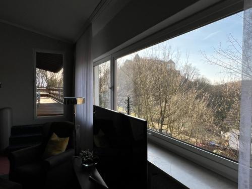 a living room with a large window and a couch at Fi-Ferienhaus in Waldeck
