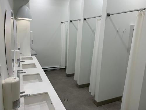 a row of sinks and mirrors in a bathroom at Auberge Jeunesse QBEDS Hostel in Quebec City