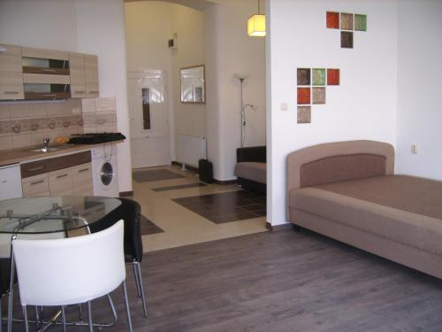 ein Wohnzimmer mit einem Bett, einem Tisch und Stühlen in der Unterkunft Next door Apartment in Budapest