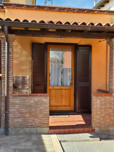 a house with a wooden door and a brick wall at Reef Fiumicino in Fiumicino