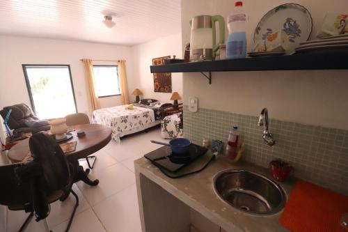 a kitchen with a sink and a table in a room at Estalagem do Rancho in Miguel Pereira