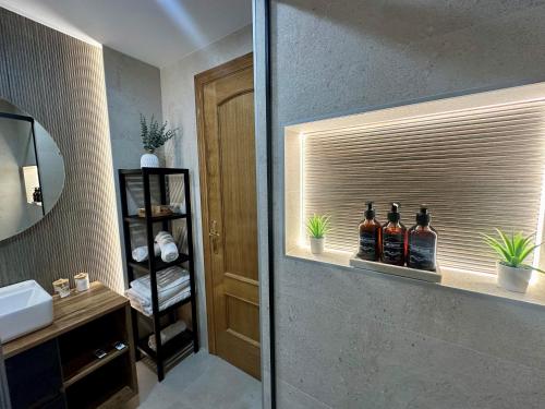 ein Badezimmer mit einem Regal mit drei Flaschen Alkohol in der Unterkunft Costa Calma y Relax in Santander