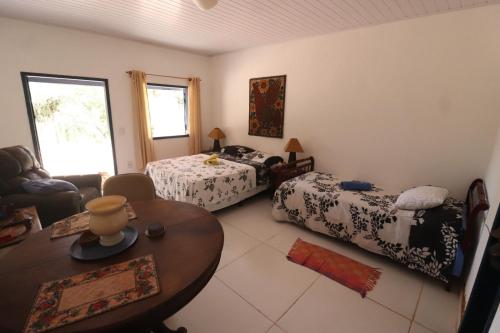 a living room with two beds and a table at Estalagem do Rancho in Miguel Pereira