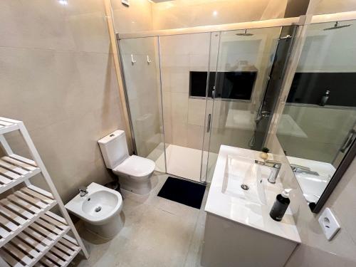 a bathroom with a toilet and a shower and a sink at Blue Dreams in Queluz