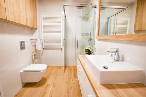 La salle de bains est pourvue de toilettes, d'un lavabo et d'une douche. dans l'établissement Apartament Siesta z widokiem na morze w Gardenia Dziwnów, à Dziwnów