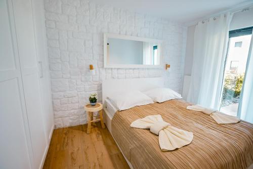 1 dormitorio con 1 cama con 2 toallas en Apartament Siesta z widokiem na morze w Gardenia Dziwnów, en Dziwnów