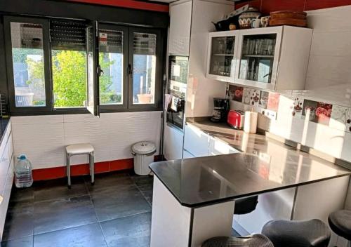 cocina con armarios blancos y encimera en Espectacular alojamiento, en Nuevo Baztán