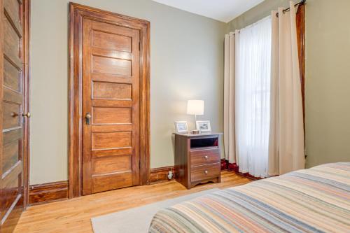 um quarto com uma cama e uma porta de madeira em Buffalo Apt with Balcony about 3 Mi to Downtown! em Buffalo