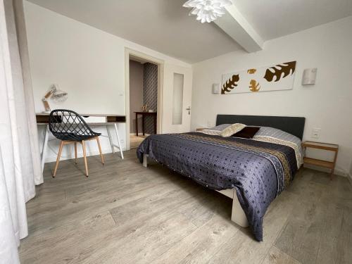 Schlafzimmer mit einem Bett, einem Schreibtisch und einem Stuhl in der Unterkunft Gite à Eguisheim proche de Colmar et Kaysergberg. in Eguisheim