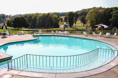 a large blue swimming pool with chairs and tables at The Highlands at Harbor Springs in Harbor Springs