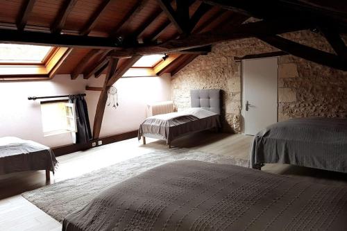 sypialnia z 2 łóżkami w kamiennym budynku w obiekcie Gîte du Louvanto w mieście Bonnes