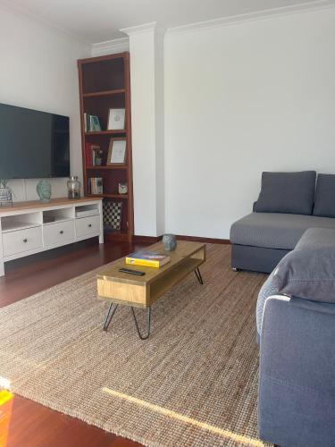 ein Wohnzimmer mit einem Sofa und einem Couchtisch in der Unterkunft Apartamento Boiro centro in Boiro