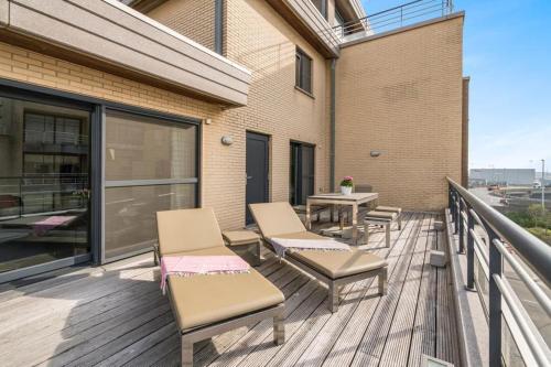 una terrazza con sedie e un tavolo in un edificio di Ruim appartement met heerlijk zonneterras a Bruges