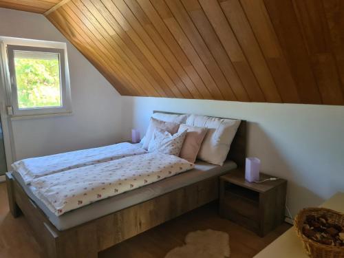 1 dormitorio con 1 cama con techo de madera en Zita Vendégház, en Dombóvár