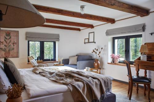 a bedroom with a bed and a couch and windows at Dobre Historie in Leśna