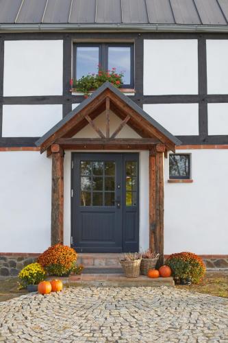 a front door of a house with pumpkins on the porch at Dobre Historie in Leśna