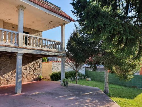 a porch on a house with a tree at Precioso chalet cerca de la playa de Samil in Vigo