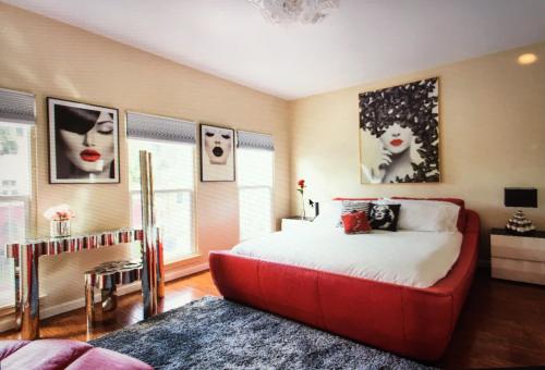a bedroom with a large bed with a red couch at Luxury 2 Bedroom Suite Apartment in Koreatown in Los Angeles