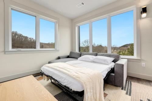 a bedroom with a bed and windows at Staggerwing-MTB Oasis in Bella Vista