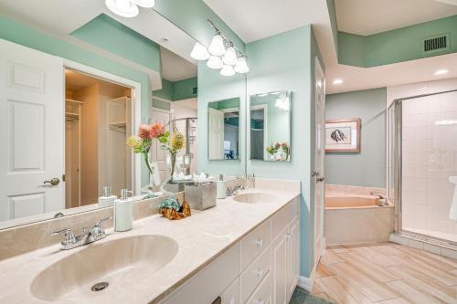 a bathroom with two sinks and a pink tub at Riverfront Fort Myers Condo with Community Amenities in Fort Myers