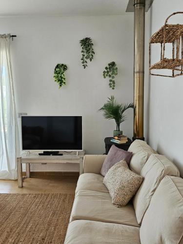 uma sala de estar com um sofá e uma televisão de ecrã plano em Casa Voramar em Cala d´Or