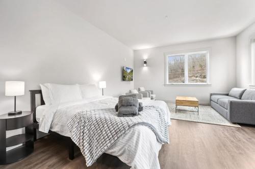 a white bedroom with a bed and a couch at Sugar Bridge-MTB Oasis in Bella Vista