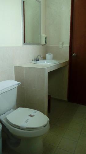 a bathroom with a white toilet and a sink at Hotel Casa de Oración San José in Puebla