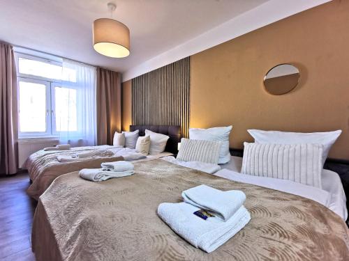 two beds in a hotel room with towels on them at BohnApartments Junior SUITE Blume 14 - Nähe Dom - WLAN in Erfurt