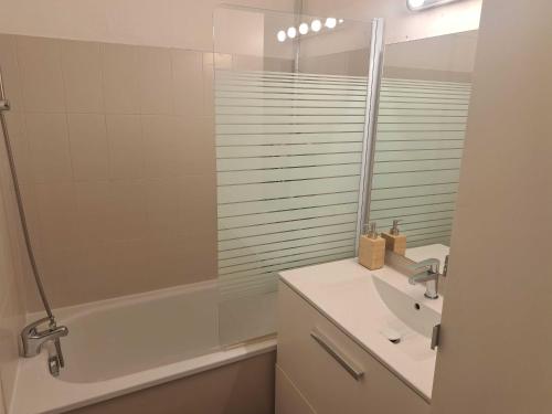 une salle de bain blanche avec un lavabo et une douche dans l'établissement T2 Centre-ville Parking, à Sète