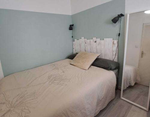 une chambre avec un lit blanc avec un miroir dans l'établissement T2 Centre-ville Parking, à Sète