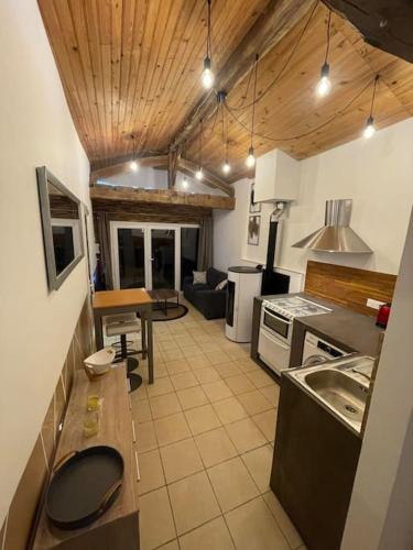 une cuisine avec une table et un comptoir dans l'établissement La Bergerie, à Thodure