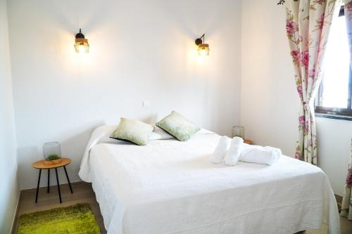 a bedroom with two beds with white sheets and a window at Villa Marrachinho in Albufeira