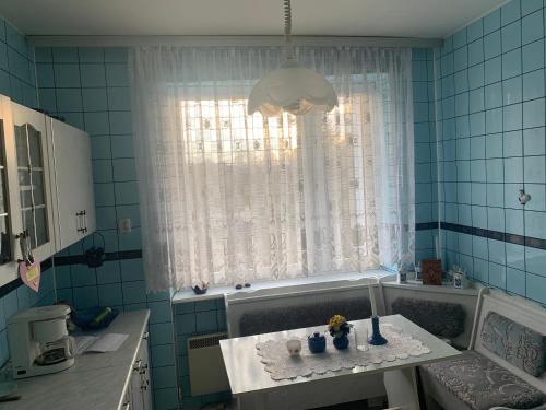 ein blau gefliestes Bad mit einem Tisch mit Blumen darauf in der Unterkunft Apartament „Jak u babci” in Jelenia Góra