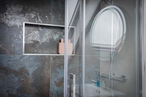 a bathroom with a shower with a mirror and a sink at Luxurious London Studios in Harrow