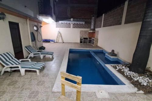 una piscina con due sedie e un tavolo di Casa Benito Agua Hedionda a Cuautla Morelos