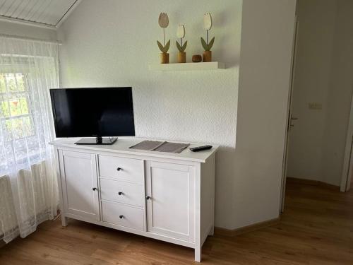 a white cabinet with a television on top of it at Idyllische Ferienwohnung in Wiefelstede in Wiefelstede