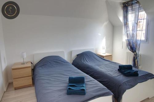1 dormitorio con 1 cama con sábanas azules y 2 toallas azules en Maison 6 personnes à 4 KMS de DISNEY, en Magny-le-Hongre
