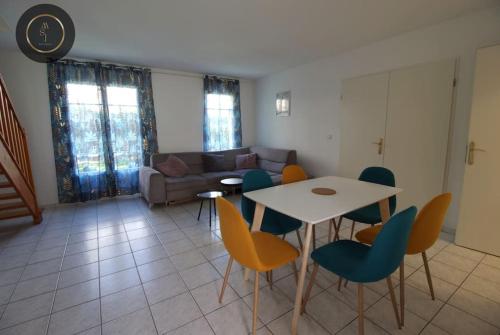 un soggiorno con tavolo, sedie e divano di Maison 6 personnes à 4 KMS de DISNEY a Magny-le-Hongre