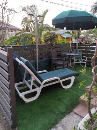 a lounge chair and an umbrella on a lawn at Lendal APT in Saint James