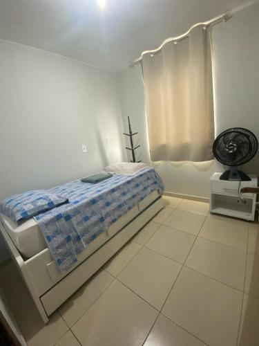 a white bedroom with a bed and a fan at Samambaia QI 616 in Brasília