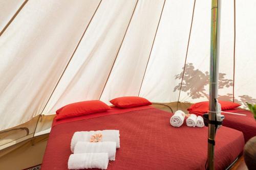een bed in een tent met handdoeken erop bij Gole Alcantara mini Glamping Lanternavacanze in Motta Camastra