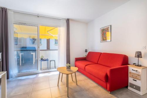 - un salon avec un canapé rouge et une table dans l'établissement Nice studio near the sea in Bandol - Welkeys, à Bandol