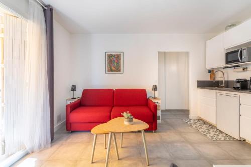 un salon avec un canapé rouge et une table dans l'établissement Studio Baldosa - Welkeys, à Bandol
