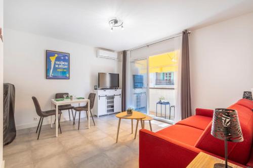 un salon avec un canapé rouge et une table dans l'établissement Studio Baldosa - Welkeys, à Bandol