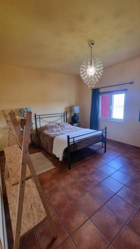 1 dormitorio con cama y lámpara de araña en Herdade do Redondo, en Escalos de Baixo