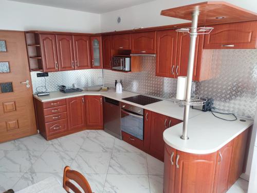 uma cozinha com armários de madeira e piso em azulejo branco em Apartament Jaśminów em Ruda Śląska
