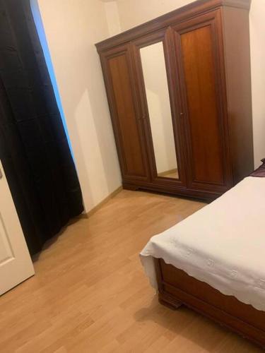 une chambre avec un lit et une armoire en bois dans l'établissement le Zola 2;terrasse;calme;centre-ville;100 m2, à Rive-de-Gier