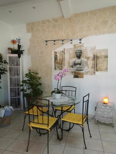 une salle à manger avec une table et des chaises en verre dans l'établissement L'hippocampe, à Saint-Mitre-les-Remparts