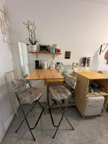 a small kitchen with a wooden table and two chairs at B&B Casa Limone in Limone sul Garda